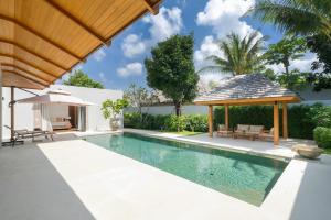 une piscine avec un kiosque et une maison dans l'établissement Anchan Tropicana 4 bedroom near Beach, à Phuket