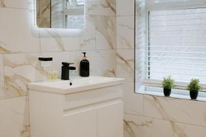 ein weißes Badezimmer mit Waschbecken und Spiegel in der Unterkunft Marine Cottage 2 - With Private Hot Tub in Newbiggin-by-the-Sea + 21 Fotos