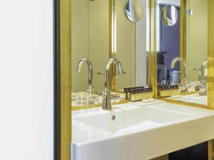 a bathroom with three sinks and two mirrors at INK Hotel Amsterdam - MGallery Collection in Amsterdam