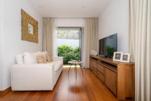 un salon avec un canapé blanc et une télévision dans l'établissement Anchan Tropicana 4 bedroom near Beach, à Phuket