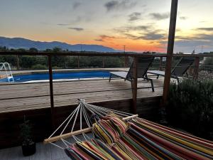 a deck with a bench and a swimming pool at Small villa with pool DOXA PETRA in Sísion