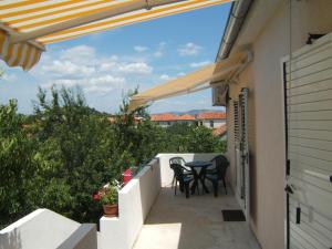 Un patio con una mesa y sillas en un balcón. en Kleines Apartment Emil Vanily, en Murter 7 fotos más