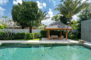 - une piscine avec un kiosque à côté d'une maison dans l'établissement Anchan Tropicana 4 bedroom near Beach, à Phuket