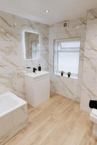 ein weißes Badezimmer mit Waschbecken und Spiegel in der Unterkunft Marine Cottage 2 - With Private Hot Tub in Newbiggin-by-the-Sea