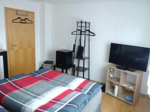 a bedroom with a bed and a flat screen tv at Jochen's Haus - Rooms, WiFi, TV in Siershahn