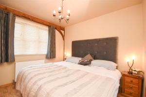 ein Schlafzimmer mit großem Bett und Fenster in der Unterkunft The Barn in Little Maplestead