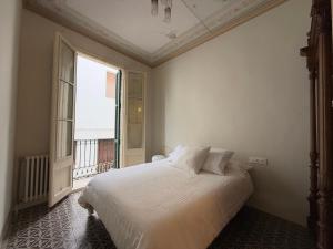 une chambre avec un lit et une grande fenêtre dans l'établissement Ca La Manso, à Sitges
