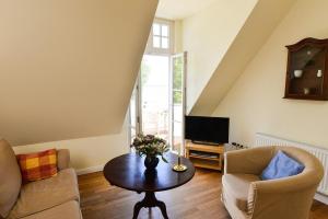 Una sala de estar con una mesa y un televisor. en Wohnung Im Zweiten Obergeschoss Des Gutshauses, en Neuenkirchen