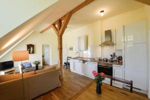 Una sala de estar con un sofá y una cocina. en Wohnung Im Zweiten Obergeschoss Des Gutshauses, en Neuenkirchen
