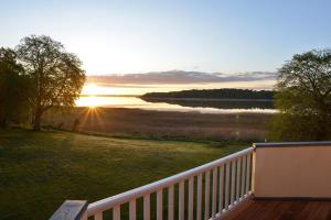 una terraza con vistas al lago y a la puesta de sol en Wohnung Im Zweiten Obergeschoss Des Gutshauses, en Neuenkirchen 10 fotos más