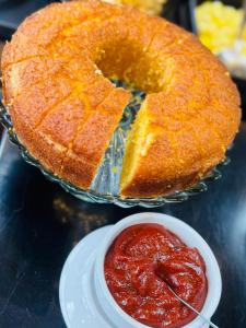 a bundt cake on a plate next to a bowl of sauce at Hotel Ibis Tatui in Tatuí +1 photo