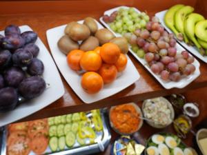 a table filled with plates of fruits and vegetables at Villa Admiral in Gdynia