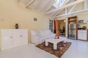 a living room with a white couch and a table at Windy Ridge Gem Studio by YourHost Karen Nairobi in Nairobi