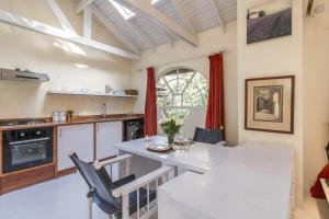 a kitchen and dining room with a white table and chairs at Windy Ridge Gem Studio by YourHost Karen Nairobi in Nairobi +24 photos