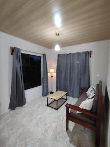 a living room with a couch and a table at Casita Guarumo in Bijagua +4 photos