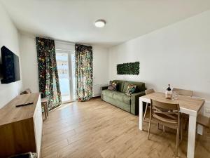 una sala de estar con un sofá y una mesa en Suite dei Principi 2, aeroporto e parcheggio gratuito, en Bari