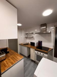 a kitchen with white appliances and a wooden counter top at Rooms Mármol, junto a Puerta Toledo in Madrid