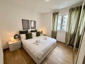 Un dormitorio con una cama blanca grande y una ventana en Suite dei Principi 2, aeroporto e parcheggio gratuito, en Bari