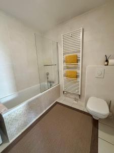 a bathroom with a tub and a toilet and a sink at Robertsau, jardin en ville in Strasbourg
