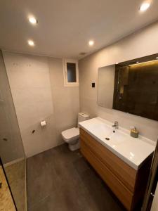 a bathroom with a sink and a toilet and a mirror at Rooms Mármol, junto a Puerta Toledo in Madrid