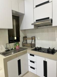 a kitchen with white cabinets and a sink at Rama Shinta Keragilan Residence in Timuran