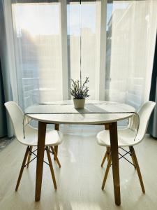 a table with two chairs and a potted plant on it at Garden Apartment in Kecskemét