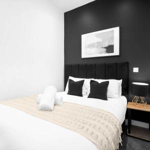 a bedroom with a large white bed with black walls at Cozy Apartment - Netflix - On Street Parking - Rowley Regis 49G in Halesowen