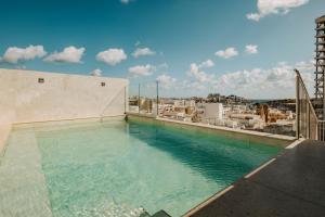 a swimming pool on the roof of a building at Regional Hotel by NEU Collective in Il-Gżira