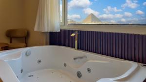 una bañera en un baño con vistas a una pirámide en pyramids palace view, en El Cairo 97 fotos más