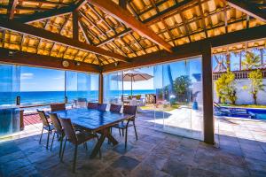 a dining room with a table and a view of the ocean at Mar a Vista Charme by Concavus in Porto De Galinhas