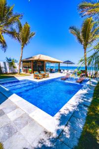a swimming pool with palm trees and a gazebo at Mar a Vista Charme by Concavus in Porto De Galinhas