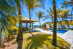 a villa with a swimming pool and palm trees at Mar a Vista Charme by Concavus in Porto De Galinhas
