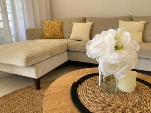 a living room with a couch and a vase with a flower at Seaside Escape with Breathtaking View in Grande Gaube +16 photos