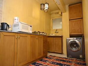 une cuisine avec un lave-linge et un micro-ondes dans l'établissement Villa Sela Gem, au Caire