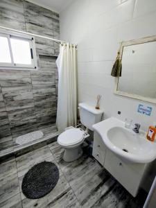 een badkamer met een wit toilet en een wastafel bij Casa con jardín Las Marías 1 in Miramar +32 foto's