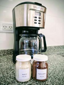 a coffee maker and two jars of honey on a counter at Casa con jardín Las Marías 1 in Miramar +37 photos