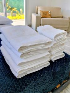 een stapel witte handdoeken op een blauw kleed bij Casa con jardín Las Marías 1 in Miramar