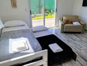 een slaapkamer met een bed, een stoel en een raam bij Casa con jardín Las Marías 1 in Miramar