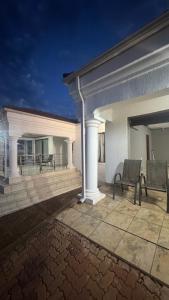 トホイアンドゥーにあるMakhuvha Tshilivho Luxury Houseのパティオのある建物とパティオに置かれた椅子 +11枚の写真