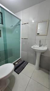 Un baño con ducha de cristal y lavabo. en Casinha de Temporada, en Cabo Frío