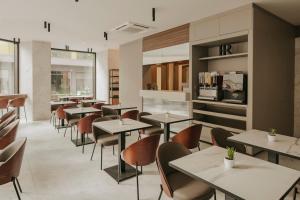 a restaurant with tables and chairs in a cafeteria at Regional Hotel by NEU Collective in Il-Gżira