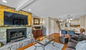 - un salon avec une grande cheminée en pierre dans l'établissement Retreat with Creekside Patio Snowmass Village, à Snowmass Village