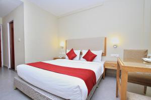 ウーティにあるTownhouse Hills Palaceの赤い枕が付いた大きなベッドのあるホテルの部屋 +17枚の写真