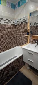 a bathroom with a white tub and a sink at studio Loubat pyrénée, ménage inclus in Arette