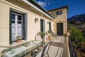 a balcony of a house with a table and chairs at Cozy Attic Suite - Elia Apartments Chrisso in Delfoi