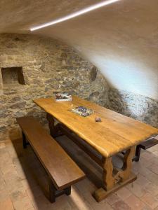 a wooden table and benches in a stone wall at Les Glaneuses Gîte Le Grand 8 centre-bourg 3 min du Puy duFou in Les Épesses