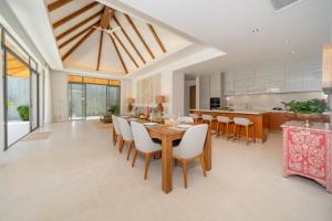 une cuisine et une salle à manger avec une table et des chaises en bois dans l'établissement Anchan Tropicana 4 bedroom near Beach, à Phuket