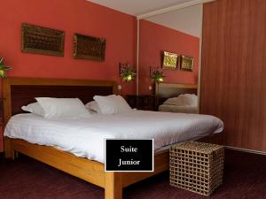 a bedroom with a bed and a mirror with a suite junior sign at Hôtel La Gentilhommière in Nuits-Saint-Georges