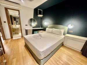 a bedroom with a white bed with a green wall at Vortex suites klcc by Kualalampur vibes in Kuala Lumpur