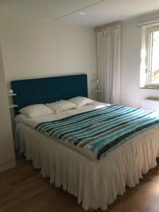 a bed with a blue headboard in a bedroom at Snäckbacken Visby in Visby +5 photos